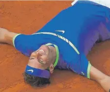  ??  ?? A joyous Rafael Nadal lies on the clay after rolling past StanWawrin­ka in straight sets to win the French Open for the 10th time.