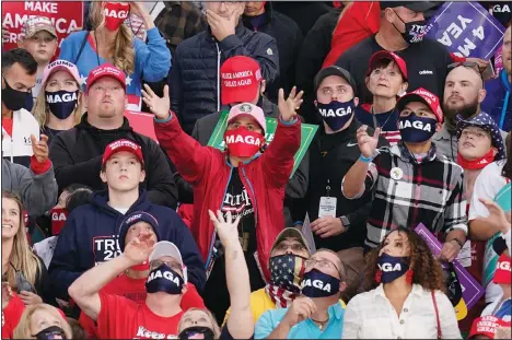  ??  ?? A supporter catches a hat before President Donald Trump’s arrival at an airport rally on Oct 14, 2020, in Des Moines, Iowa. (AP)