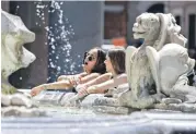  ?? / EFE ?? Dos turistas se refrescan en una fuente de Roma, Italia.