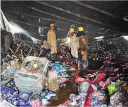  ?? — PTI ?? Fire brigade personnel douse a fire which broke out in a factory at Pratap Nagar industrial area in New Delhi on Saturday.