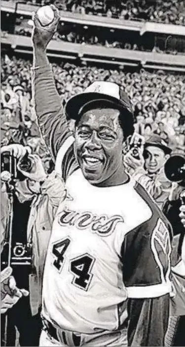  ??  ?? Hank Aaron holds the ball he hit for his 715th career home run on April 8, 1974, at Atlanta Stadium against the Los Angeles Dodgers.