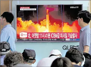  ?? AP/AHN YOUNG-JOON ?? People at a railway station in Seoul, South Korea, watch Saturday as a television news report shows North Korea’s latest test launch of an interconti­nental ballistic missile.
