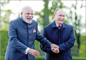  ?? REUTERS ?? Prime Minister Narendra Modi and Russian President Vladimir Putin react while walking near the Constantin­e Palace during their meeting in St. Petersburg, Russia, on Thursday.