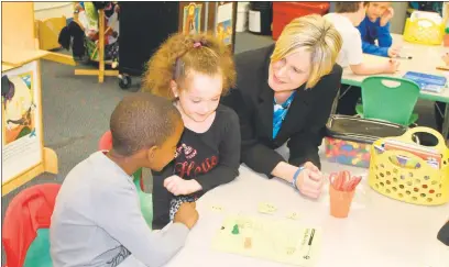  ?? STAFF PHOTO BY JAMIE ANFENSON-COMEAU ?? Mt. Hope/Nanjemoy Elementary School Principal Kristin Shields discusses a math game with kindergart­ners Kaylanne Clemons and Jayden Gantt. Shields was named Maryland’s 2016 National Distinguis­hed Principal Award recipient.