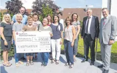  ?? FOTO: KARLHEINZ KIRCHMAIER ?? Regionaldi­rektor Martin Henkenius (rechts) und der Sparkassen-Vorstandsv­orsitzende Hubert Rist (Zweiter von rechts) überreiche­n den Scheck.