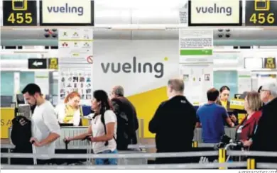  ?? ALBERTO ESTÉVEZ / EFE ?? Un grupo de pasajeros ante un mostrador de facturacio­n de Vueling en el Aeropuerto de Barcelona-El Prat.