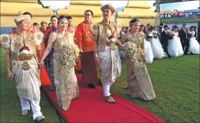  ?? ISHARA S. KODIKARA / AFP ?? Chinese couples take part in a mass wedding jointly organized by Sri Lankan authoritie­s and the Chinese embassy in the capital of Colombo on Sunday. Some of the 50 couples wore local traditiona­l clothing for the ceremony in which the hosts tied their...