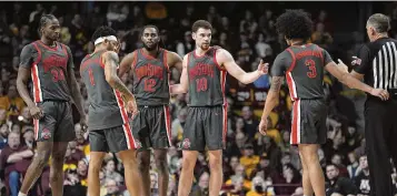  ?? ABBIE PARR / ASSOCIATED PRESS ?? Ohio State center Felix Okpara (34), guard Roddy Gayle Jr. (1), guard Evan Mahaffey (12), forward Jamison Battle (10) and guard Taison Chatman (3) stand on the court during the second half of an NCAA college basketball game against Minnesota in Minneapoli­s on Thursday.