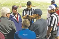  ?? WILL WEBBER/THE NEW MEXICAN ?? Deming and Capital coaches, administra­tors and referees gathered late Friday as they debated whether to finish the game. A bolt of lightning overhead prompted the head referee to call it during the third weather delay.