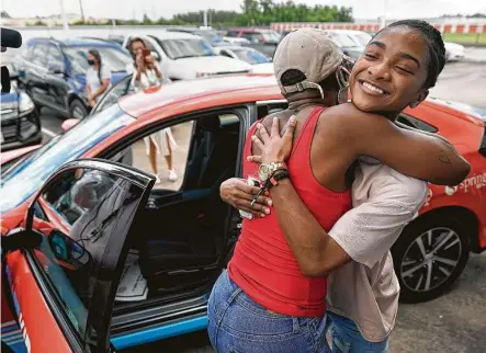  ?? Melissa Phillip / Staff photograph­er ?? Tameca Spence, left, hugs her daughter, Erion Spencer, 18, a Wunsche High School senior, after she won a new Honda Civic LX.