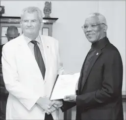  ??  ?? Lt Col (rtd) Russell Combe (at left) handing over the plan to President David Granger in January