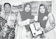 ??  ?? REDONAH (kanan) menyampaik­an anugerah Tokoh Guru SK Koromoko 2017 kepada Siti Umairah Maliki sambil disaksikan oleh Asmara (kiri).