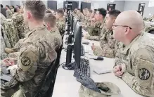  ??  ?? U.S. soldiers from Task Force Griffin receive a briefing as they prepare to deploy to help Customs and Border Protection and other supporting interagenc­y partners secure the Mexican border.