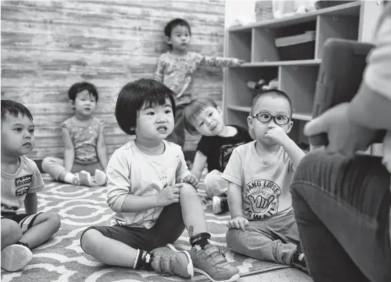  ?? Photos by Pu Ying Huang / Contributo­r ?? Kayla Cheng, 2, listens to her teacher describe a science experiment in English and Mandarin at the Early Learning Center in the Chinese Community Center.