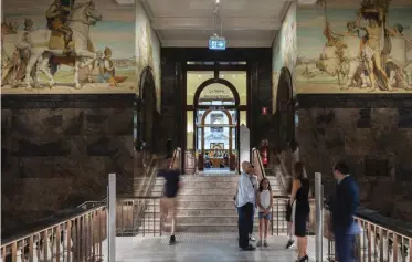  ??  ?? Above the polished stone stair at the entrance to the Ian Potter Queen’s Hall, two 1920s murals (by Harold Septimus Power and Napier Waller) have been conserved.