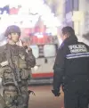  ?? PHOTO: TNS ?? Tense scene . . . Emergency responders confer after a report of shots fired in downtown Strasbourg. Witnesses had reported hearing a police helicopter overhead before it was announced the suspect was killed.