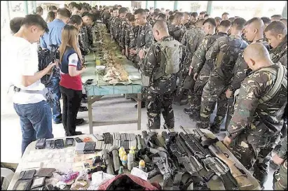  ?? JOHN UNSON ?? Soldiers pray before taking part in a ‘boodle fight’ yesterday after killing the alleged leader of a local drug ring and two of his henchmen in a reported shootout at the border of Datu Paglas and Pandag towns in Maguindana­o. In the foreground are...