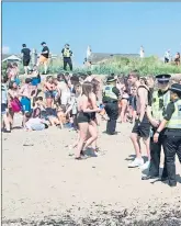  ??  ?? Police officers stand guard on Troon Beach last week as temperatur­es soar on Bank Holiday Monday