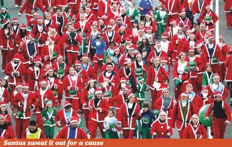  ?? Reuters ?? Participan­ts dressed in Santa Claus outfits take part in a charity race in Madrid, Spain yesterday. More than 7,000 ran in the event to raise money for cancer care and research. Organisers say the Santa-themed race is the largest of its kind in the world.