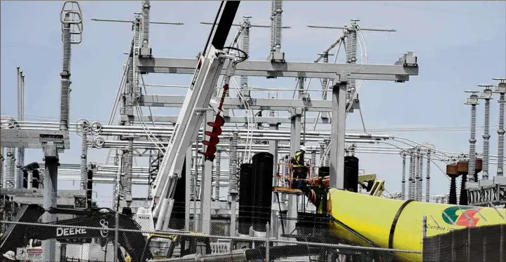  ?? Photos by Will Waldron / Times Union ?? Workers make upgrades to the National Grid electrical substation at Game Farm and News Scotland South roads on April 18 in New Scotland. National Grid says it wants to eliminate fossil fuel natural gas in favor of biogas and green hydrogen by 2050 — a dramatic shift in the utility industry.