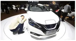  ?? — AP ?? What’s under here?: A visitor taking a closer look at the Sylphy Zero Emission during an auto show in Beijing.