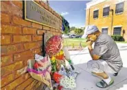  ?? THE ASSOCIATED PRESS ?? After placing flowers Saturday at a makeshift memorial, Miguel Velez says a prayer for two officers killed in Kissimmee, Fla.