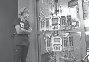  ?? GERALD HERBERT/AP FILE ?? Nursing coordinato­r Beth Springer looks into a COVID-19 patient’s room Aug. 17 at the Willis-knighton Medical Center in Shreveport, La.