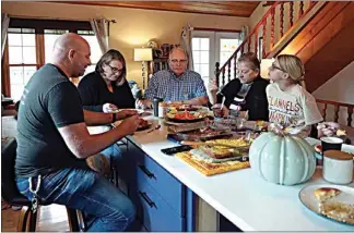  ?? SHELBY LUM / AP ?? Doug Whitney, center, eats breakfast with his family in Manson, Wash., on Nov. 5.