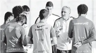  ?? Paulo Whitaker - 14.jun.16/Reuters ?? Tite, no centro, conversa com os jogadores do Corinthian­s durante treino no CT do Parque Ecológico; treinador viajou ontem ao Rio para falar com a CBF