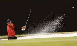  ?? David Cannon / Getty Images ?? Tiger Woods plays his shot from the bunker on the third hole during the final round of the Masters at Augusta National Golf Club on April 10.