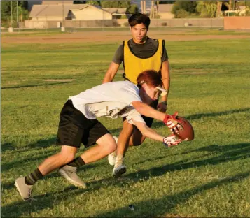  ?? Buy these photos at YumaSun.com PHOTOS BY GRADY GARRETT/YUMA SUN ?? ABOVE: CIBOLA WIDE RECEIVER JESSE CHAVEZ tries to corral a pass in front of cornerback Gabriel Ramirez during Monday evening’s practice at Cibola. BELOW: Yuma Catholic football players run sprints during Monday evening’s practice at YC.