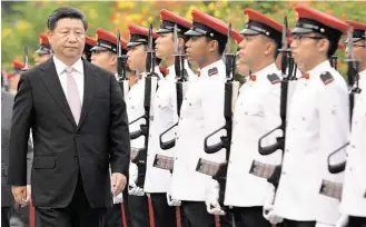  ?? Mohd Fyrol / Pool photo via Associated Press ?? Chinese President Xi Jinping reviews the guard of honor at a welcoming ceremony in Singapore on Friday. Xi is scheduled to meet with Taiwan’s President Ma Ying-jeou today.