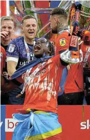  ?? /Reuters ?? Premier League here we come: Luton Town's Pelly-Ruddock Mpanzu celebrates with the trophy after winning the Championsh­ip play-off final.