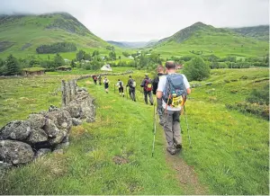  ??  ?? Major Andrew Wedderburn, top, flanked by Les Binns, left, and Tom CuffBurnet­t of ABF The Soldiers’ Charity, and below, an earlier Cateran Yomp.