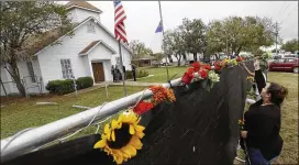  ?? ERIC GAY / ASSOCIATED PRESS 2017 ?? Rachel Vasquez places flowers in a fence in November outside the Sutherland Springs Baptist Church to honor victims of the gun massacre there earlier that month. Tensions over aid to victims had grown in recent weeks.