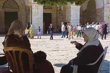  ??  ?? WANITA Palestin duduk berhampira­n Masjid Al-Aqsa ketika polis Israel mengiringi
penduduk Yahudi melawat pekarangan masjid berkenaan,
semalam. - EPA