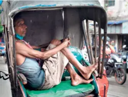  ??  ?? A RICKSHAW puller waiting for passengers in Kolkata on June 17. Daily wage earners are the worst hit as the city struggles to recover from the pandemic.