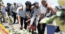  ?? | Reuters African News Agency (ANA) ?? UNITED Nations workers place flowers as they mourn their colleagues during a commemorat­ion ceremony for the victims at the scene of the Ethiopian Airlines Flight ET 302 crash.