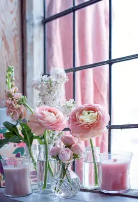 ??  ?? Left: Arrange summer blooms in mismatched vases and jars to make a simple but stunning display. The pink ranunculus costs £3.99 for a pot and the Yankee Woodwick candles in a jar cost £18.99 each. All are available from Dobbies Garden Centres (dobbies.com)