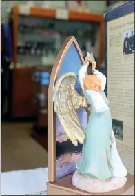  ??  ?? An angel statuette in the window of Guardian Church Goods on West Seventh Street remains among the merchandis­e yet to be sold as the store enters its final weeks.
