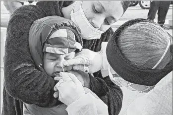  ?? ELISE AMENDOLA/AP ?? Jamillette Gomes holds her 2 year-old son Avian as he receives a COVID-19 test Thursday in Lawrence, Massachuse­tts.