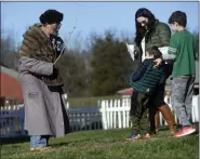  ?? BILL UHRICH — READING EAGLE ?? Orrin Krut, 5, recoils in terror of the Belsnickel, a.k.a. Keith Brintzenho­ff of Kutztown, into the arms of his mom Hillary and brother Cohen, 7, all of Phoenixvil­le, during the Homestead Holiday Saturday at the Daniel Boone Homestead in Exeter Township.