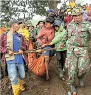  ?? /Reuters ?? Volcanic victim: Indonesian rescue teams carry the body of a Mount Marapi eruption victim.