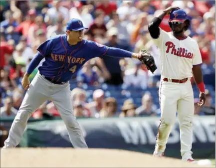  ?? MATT SLOCUM — THE ASSOCIATED PRESS ?? Philadelph­ia Phillies’ Odubel Herrera, right, is tagged out by New York Mets third baseman Wilmer Flores after trying to advance on a flyout by Nick Williams during the fifth inning of a baseball game, Sunday in Philadelph­ia.