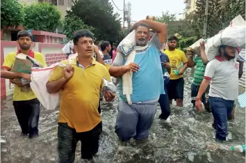  ?? SONU KISHAN ?? RESCUE ACT
Pappu Yadav and his aides wade through a flooded Patna street with relief material in September