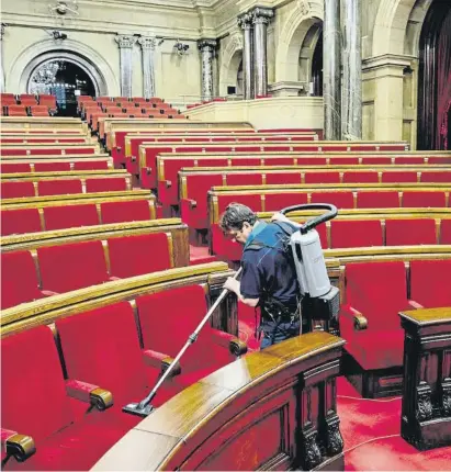  ?? À xGar ia ?? TODO LıSTO
Un empleado del Parlament limpia los asientos del hemiciclo ahora vacío a la espera de que en unas semanas vuelva a ser ocupado por los nuevos electos