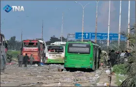  ?? AP/Thiqa News ?? Damaged buses sit at an evacuation point Saturday outside Aleppo, Syria, after an explosion killed at least 100 people.