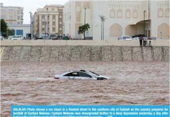  ?? — AFP ?? SALALAH: Photo shows a car stuck in a flooded street in the southern city of Salalah as the country prepares for landfall of Cyclone Mekunu. Cyclone Mekunu was downgraded further to a deep depression yesterday, a day after lashing the southern coast of...