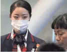  ?? MARIO TAMA/GETTY IMAGES ?? A Japan Airlines worker wears a face mask at Los Angeles Internatio­nal Airport.