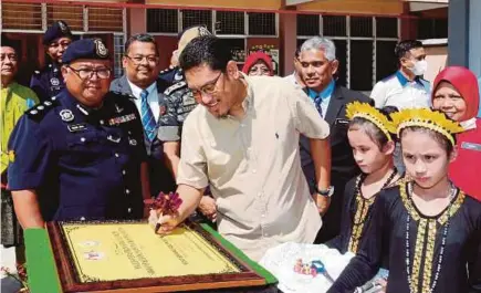  ?? (Foto L Manimaran/bh) ?? Ahmad Faizal menandatan­gani plak perasmian Surau Al-faizin Sekolah Kebangsaan Polis Hutan di Kem Pasukan Gerak Am Ulu Kinta, semalam.